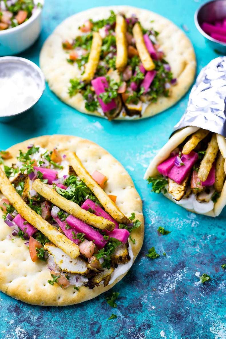 overhead: thin slices of chicken and vegetables with tabouli on flat pita bread