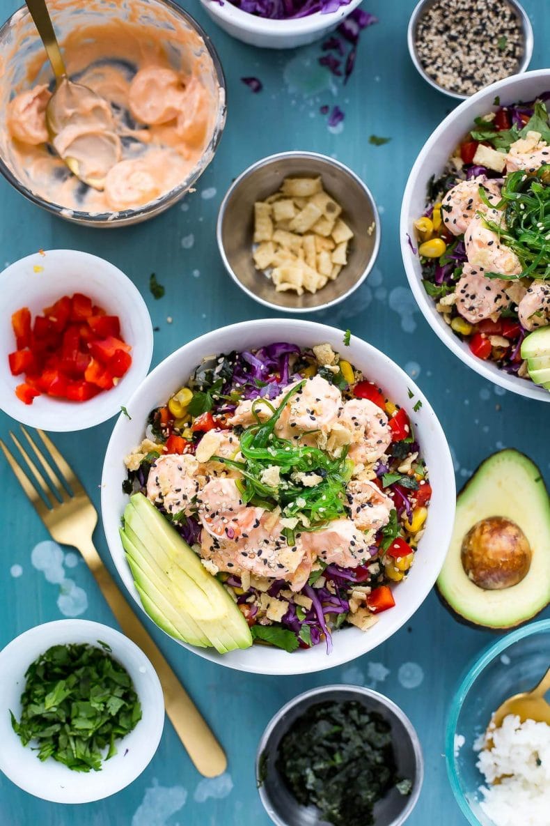 These Creamy Sriracha Shrimp Poke Bowls are a delicious twist on a traditional tuna poke with seaweed salad, lemongrass corn, avocado and wonton strips!