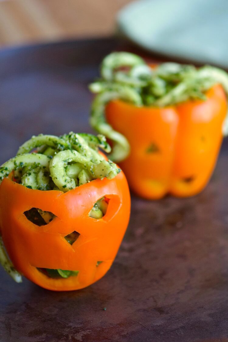 zoodles with pumpkin kale pesto stuffed inside a bell pepper carved like a Jack O Lantern