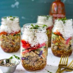 Three chicken spring roll jars in the background with one chicken spring roll jar in the foreground.