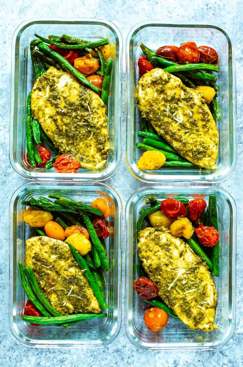 4 meal prep containers filled with baked chicken breast and roasted fresh vegetables