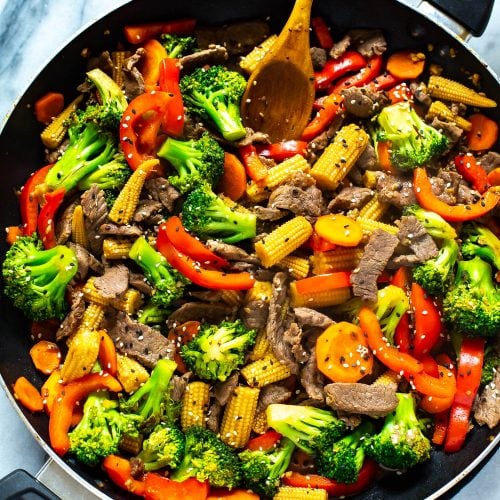 Beef stir fry in a black skillet.