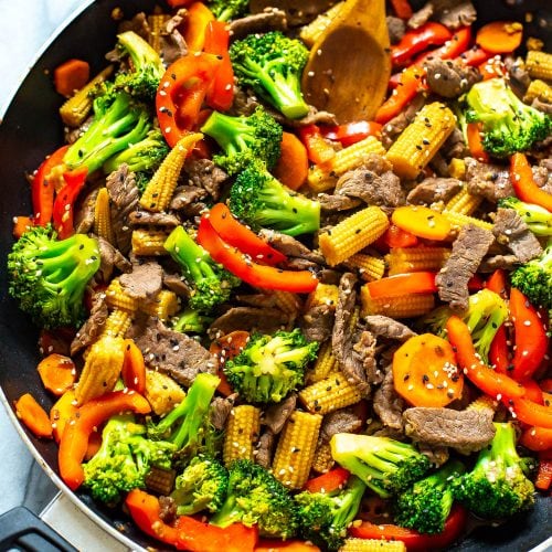 Beef stir fry in a black skillet.