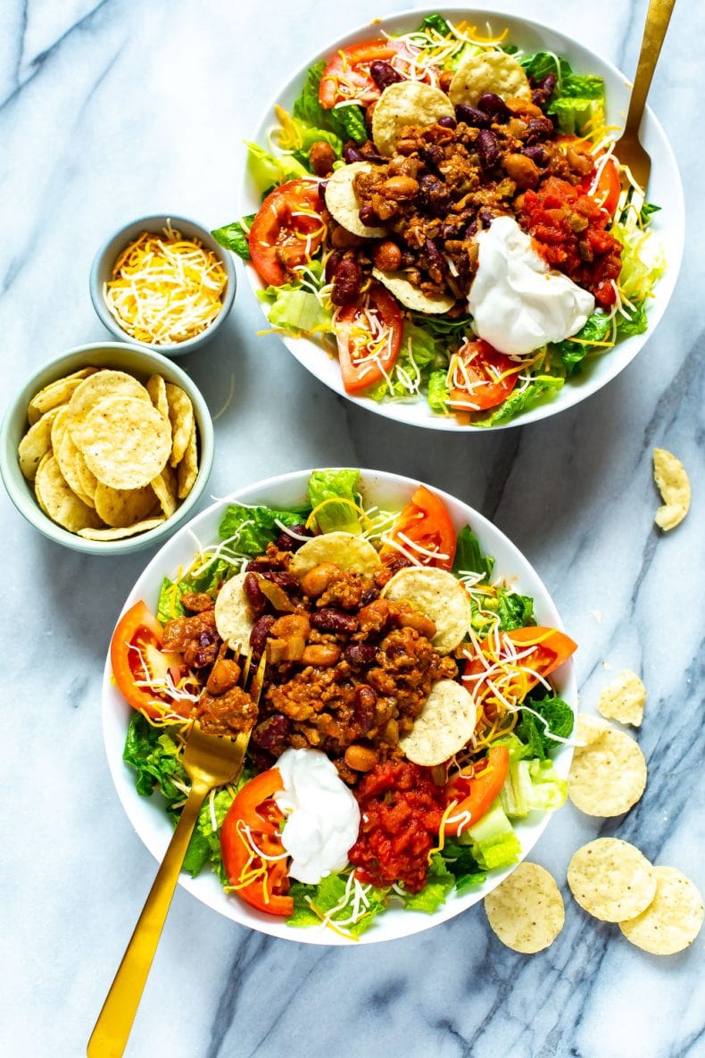 2 bowls of chili taco salad surrounded by tortilla chips