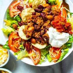 A close-up of a bowl of Copycat Wendy's Taco Salad with a fork in it.