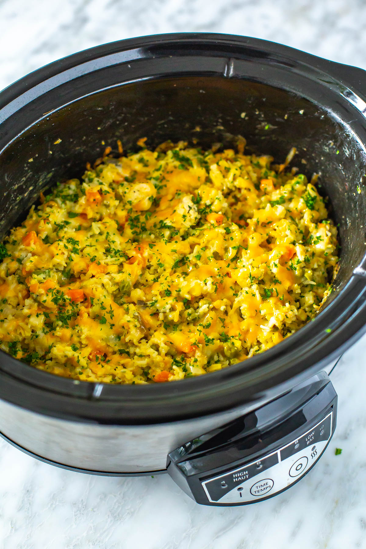 A slow cooker with crockpot chicken and rice inside.