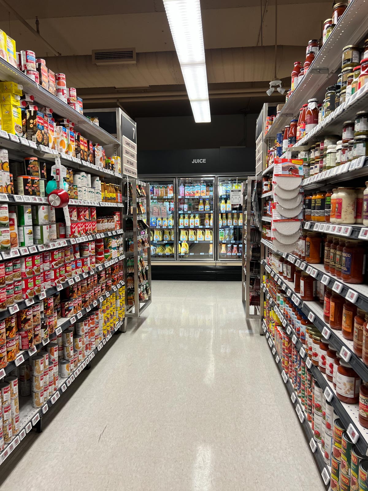 The canned goods aisle at the grocery store, including the juice section at the back.
