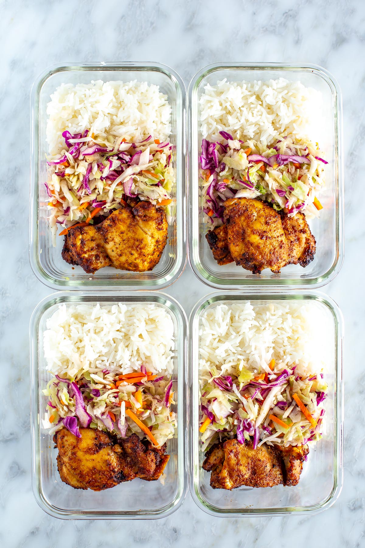 Chicken thighs with coleslaw and rice in meal prep bowls