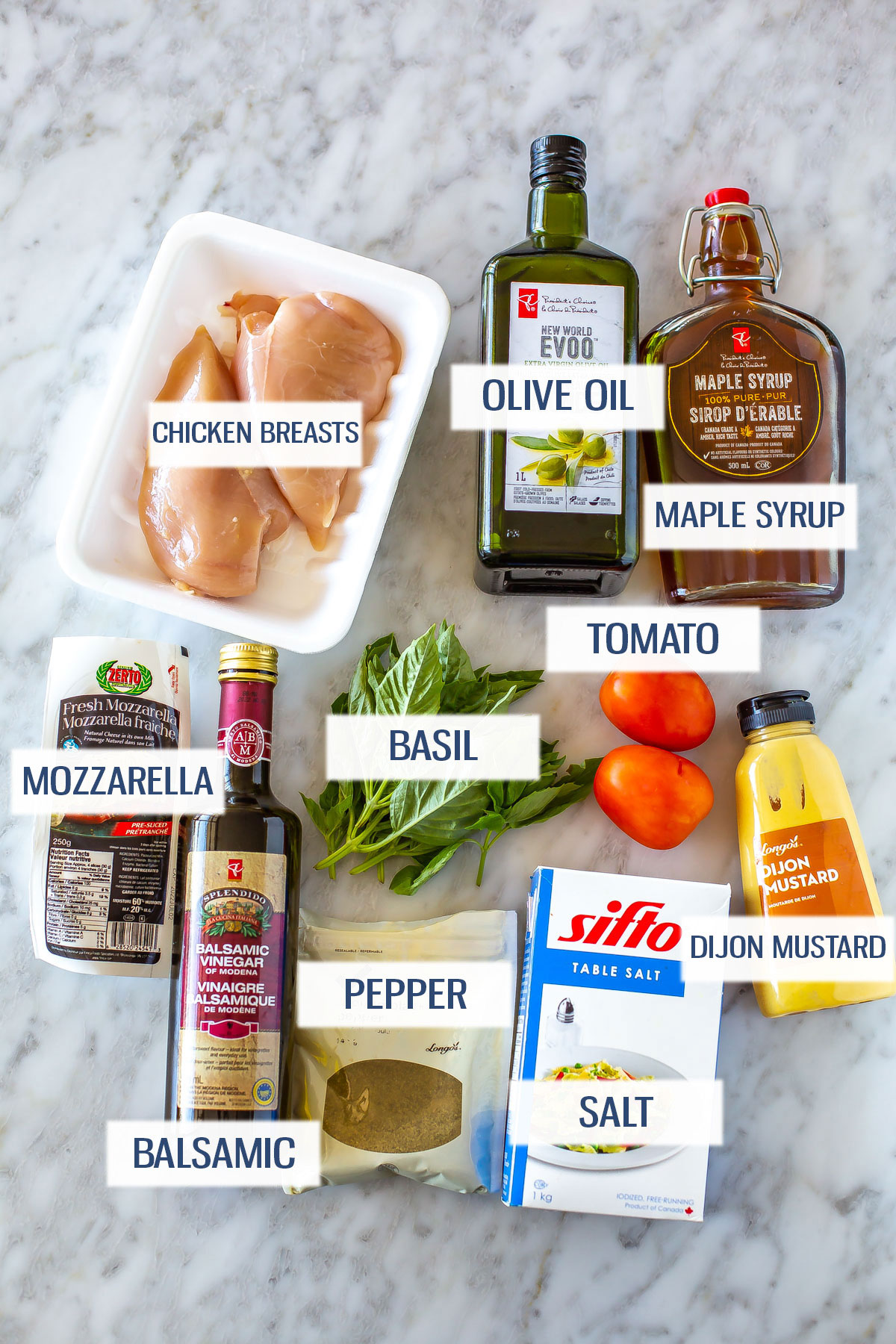 Ingredients for hasselback caprese chicken: chicken breasts, olive oil, maple syrup, mozzarella, balsamic vinegar, salt, pepper, basil, tomatoes and Dijon mustard.