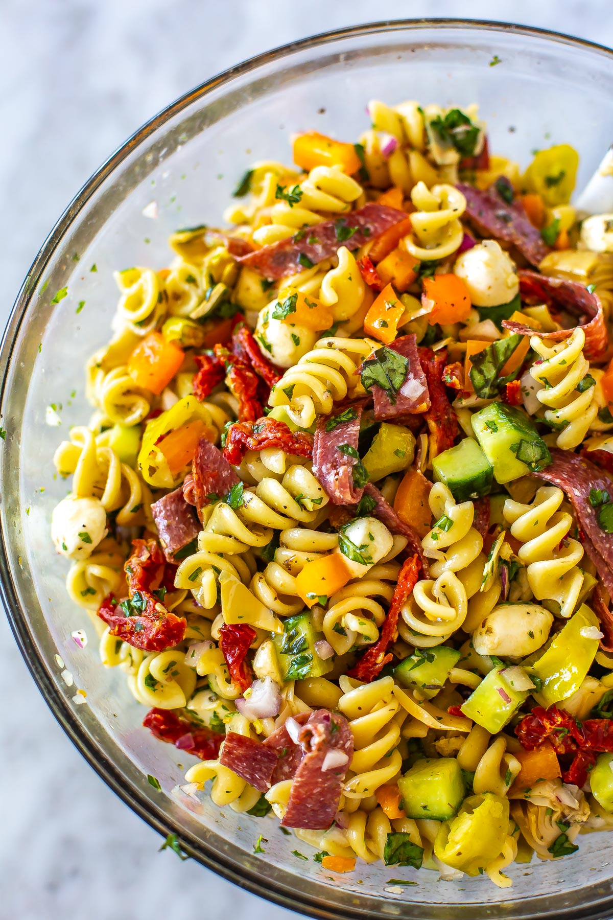 A close-up of a big bowl filled with Italian pasta salad.
