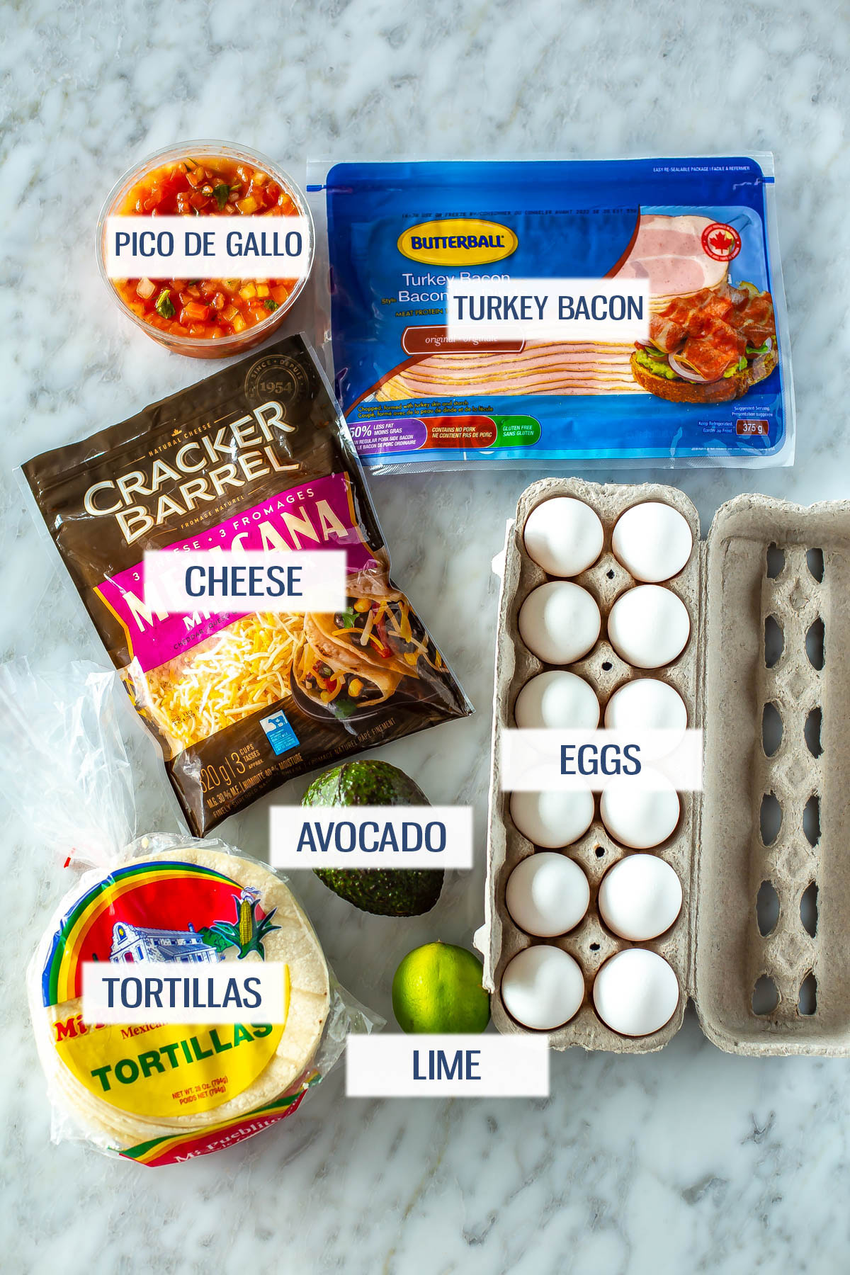 Ingredients for breakfast tacos: pico de gallo, turkey bacon, cheese, eggs, avocado, tortillas, and lime. 