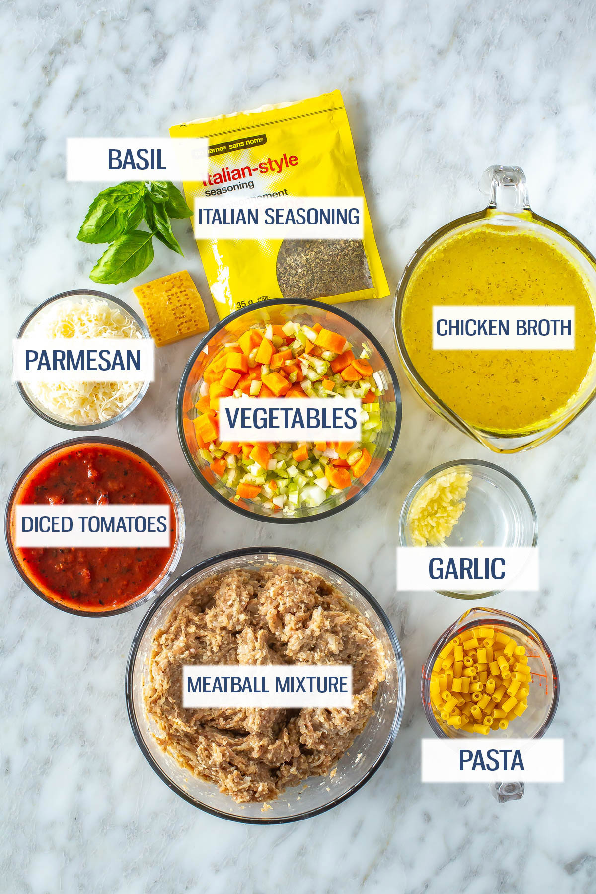 Ingredients for Italian turkey meatball soup: basil, Italian seasoning, chicken broth, parmesan, vegetables, diced tomatoes, garlic, meatball. mixture and pasta.