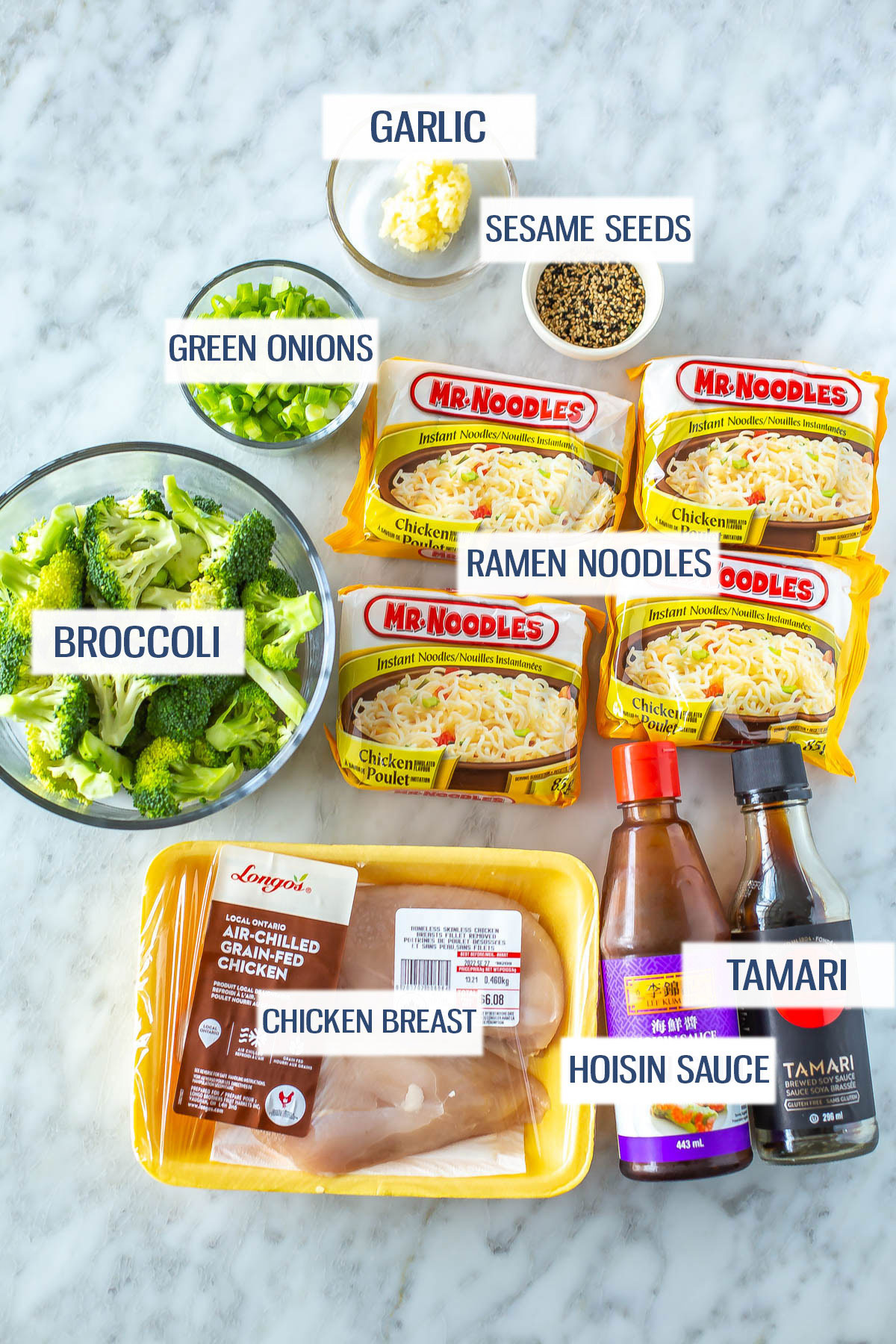 Ingredients for chicken ramen stir fry: ramen noodles, garlic, sesame seeds, green onions, broccoli, chicken, hoisIn sauce and tamari.