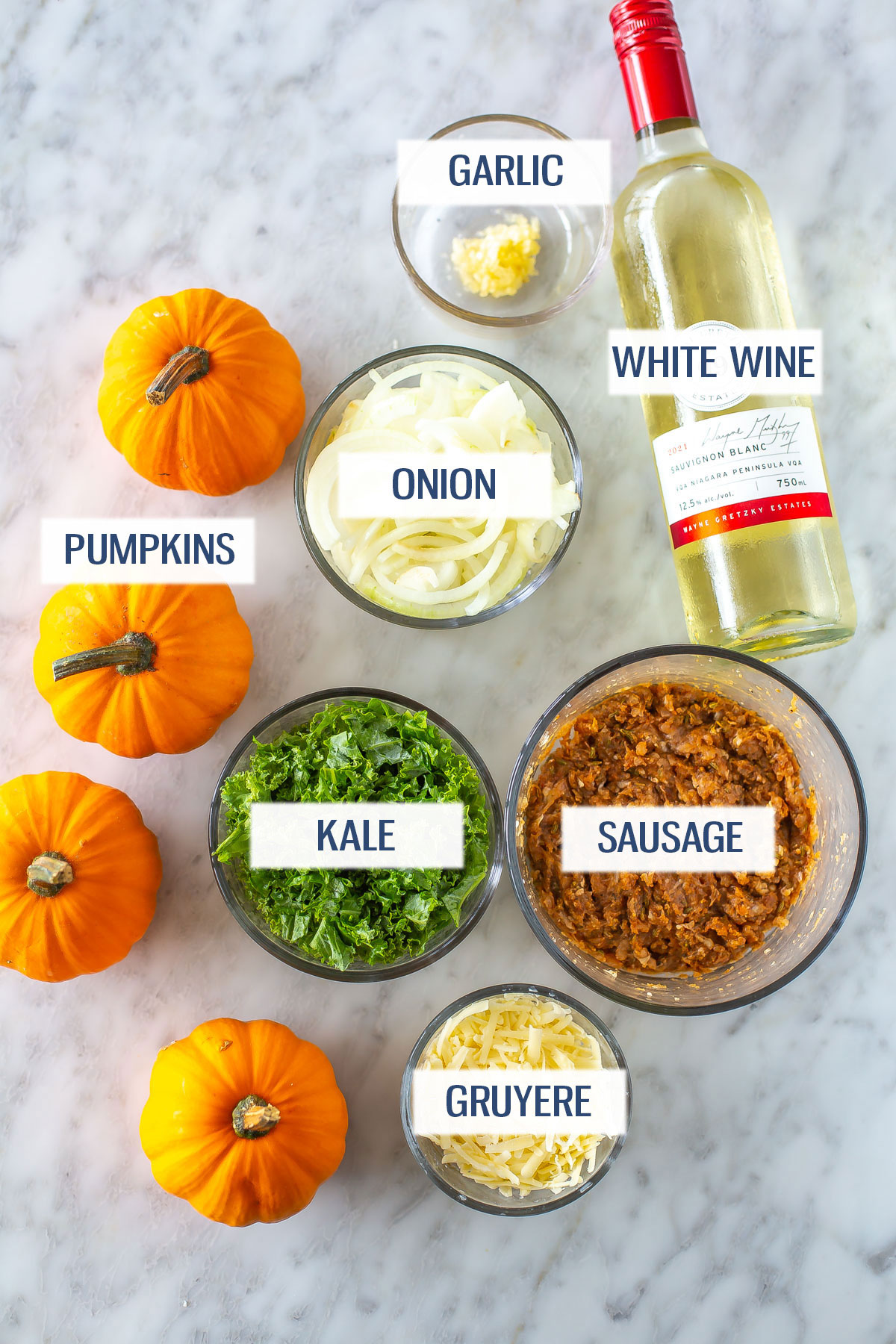 Ingredients for stuffed pumpkins: mini pumpkins, onion, garlic, white wine,  kale, turkey sausage, and gruyere cheese.