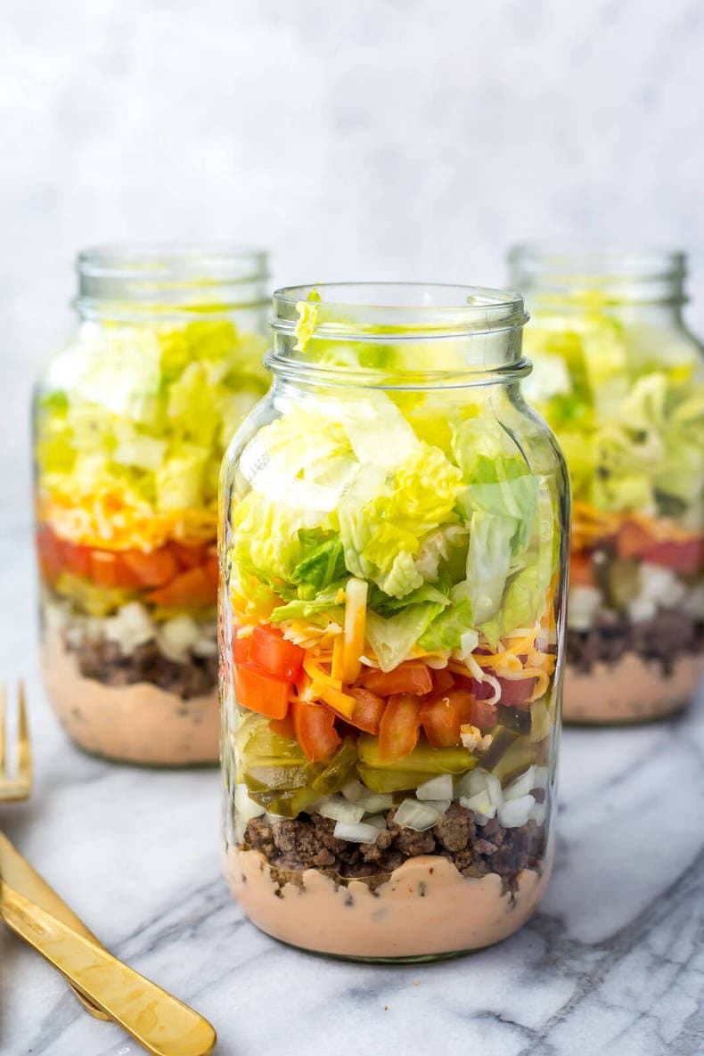 Three low carb Big Mac Salad Jars that have been meal prepped.