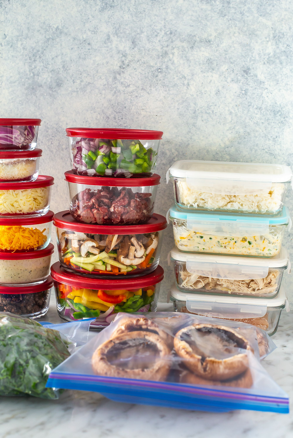 Several prepped ingredients in glass containers and Ziploc bags.