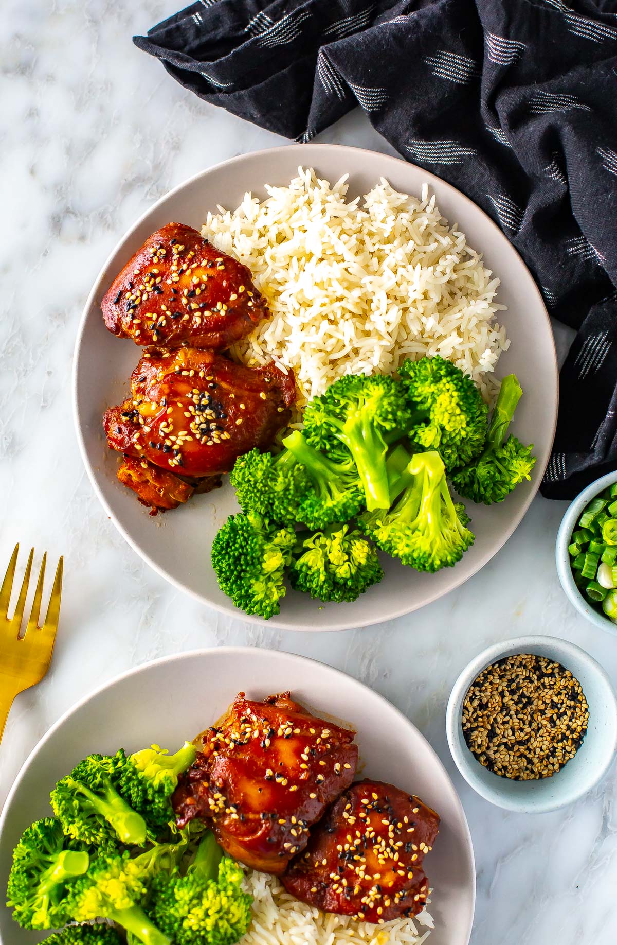 A plate of slow cooker honey garlic chicken thighs served with broccoli and rice.