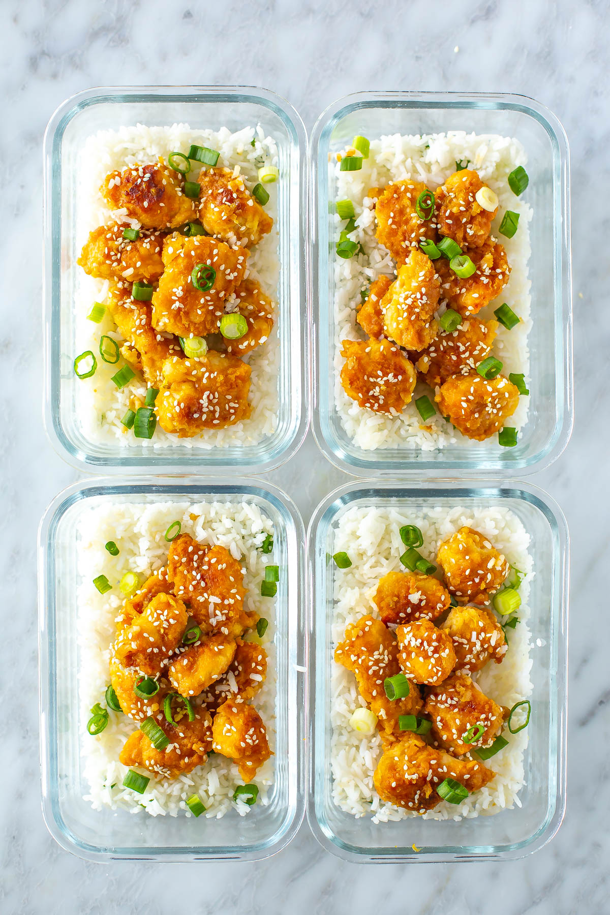 Four meal prep containers, each with a serving of Panda Express orange chicken.