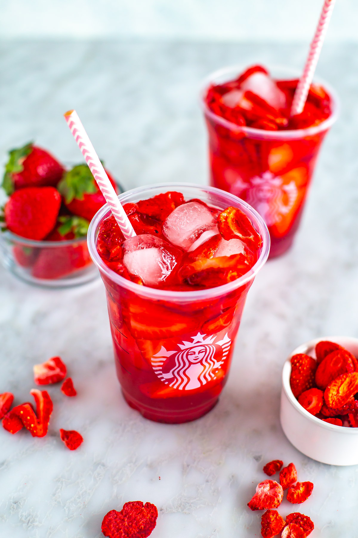 An overhead shot of two glasses of Starbucks strawberry acai refresher.