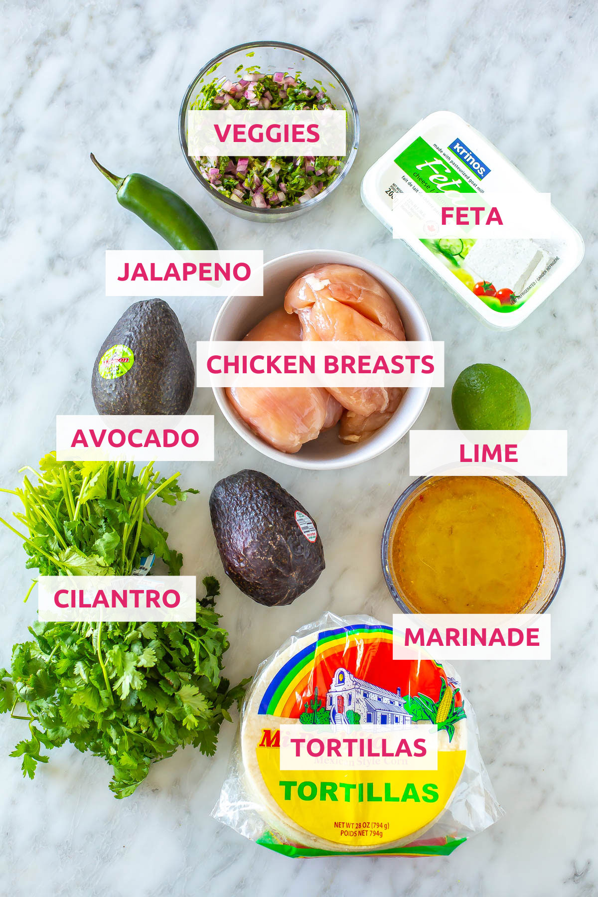 Ingredients for cilantro lime chicken tacos: veggies, jalapeno, feta, marinade, chicken breasts, avocado, cilantro and tortillas.