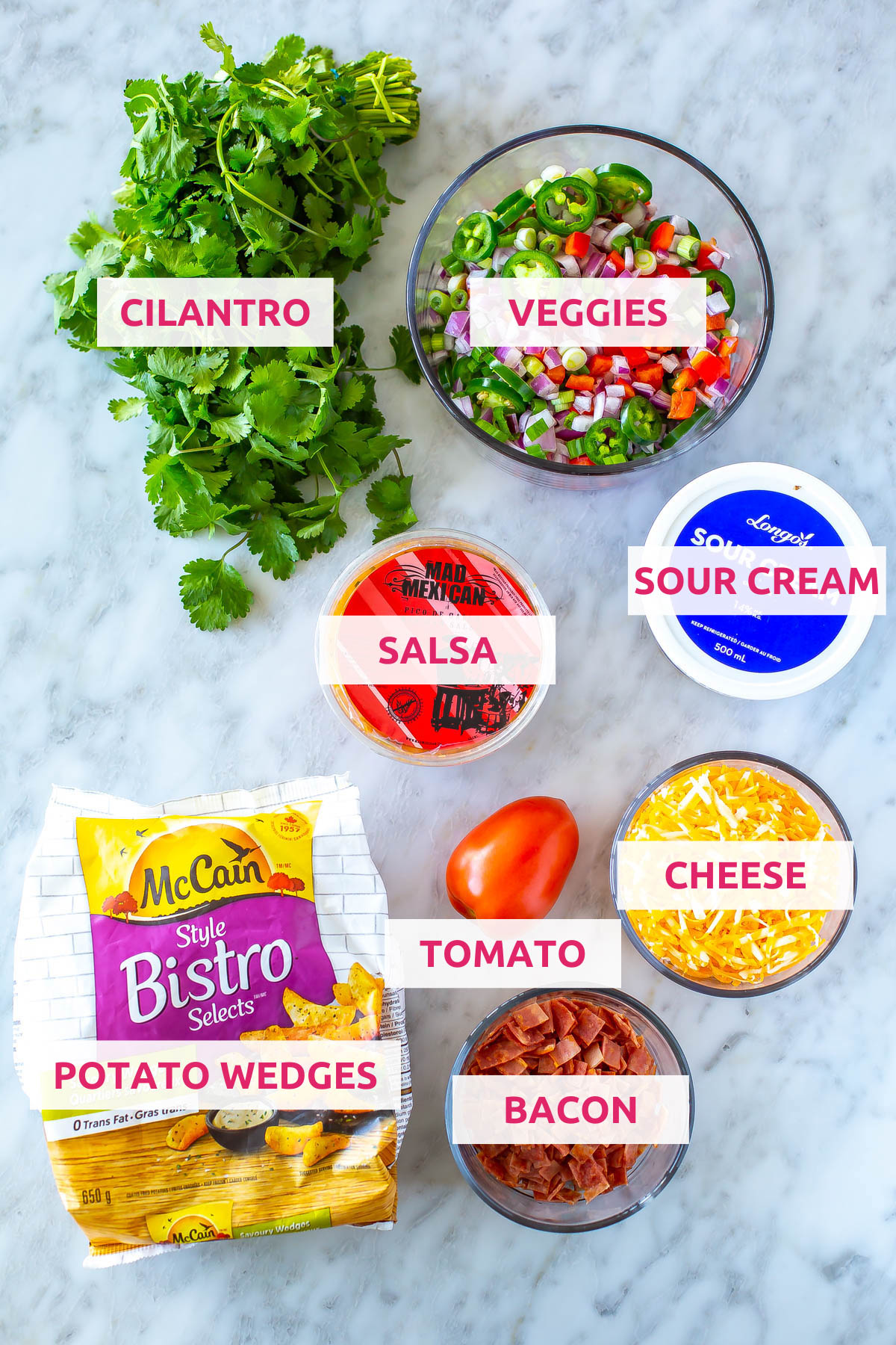 Ingredients for Irish nachos: potato wedges, turkey, tomato, cheese, sour cream, salsa, cilantro, and veggies.