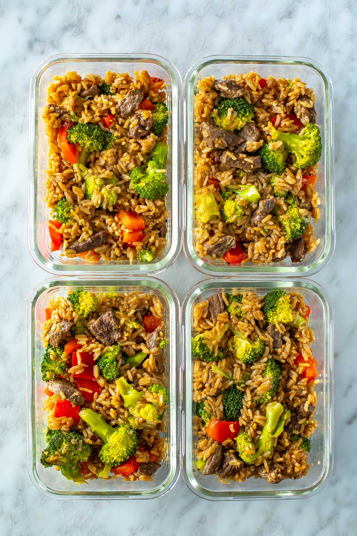 Four meal prep containers, each with a serving of Instant Pot beef and broccoli.