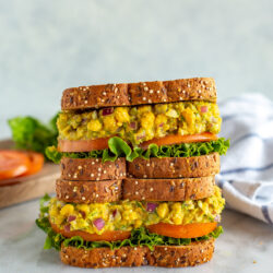 Two chickpea tuna salad sandwiches stacked on top of each other.