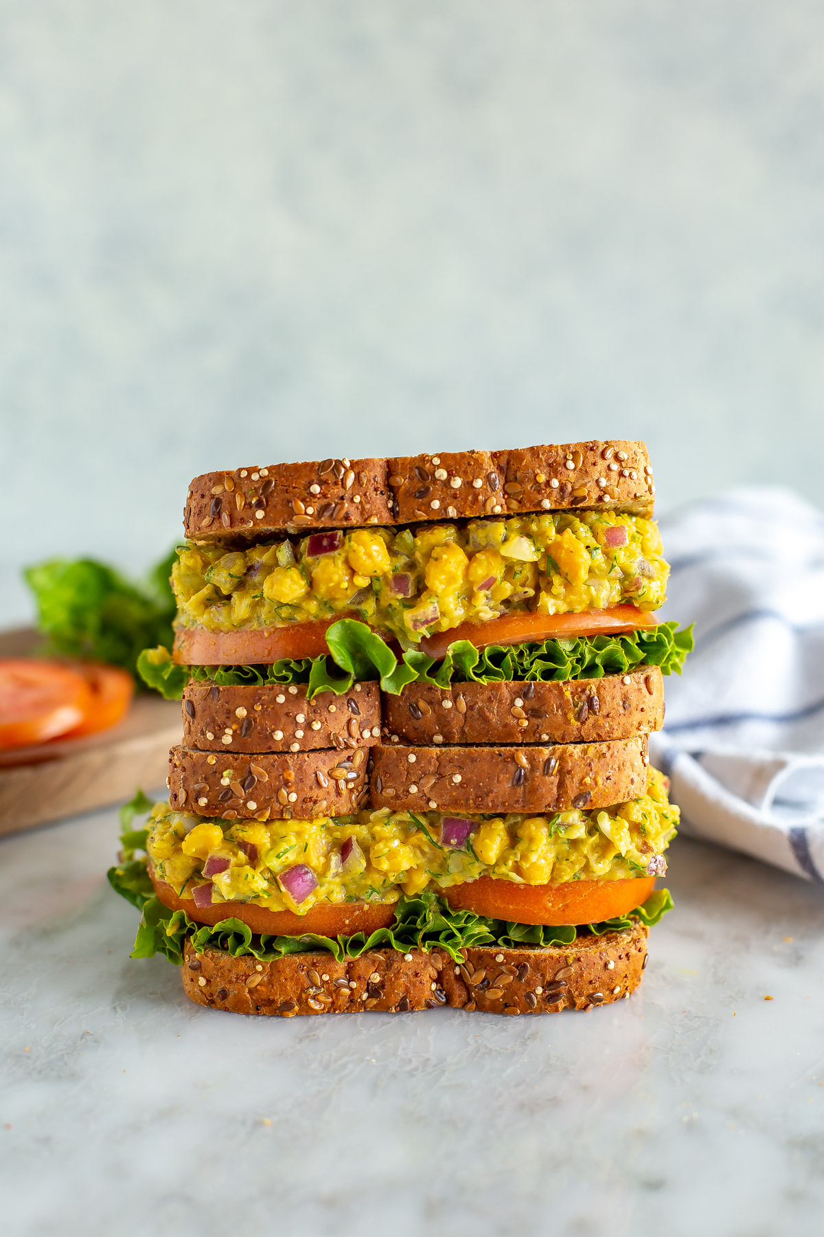 Two chickpea tuna salad sandwiches stacked on top of each other.