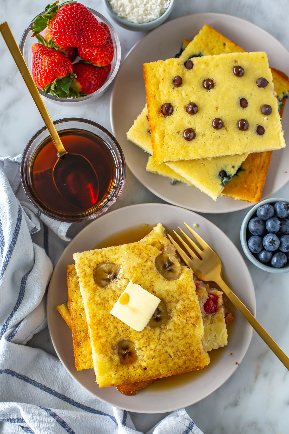 A stack of sheet pan pancakes with butter and maple syrup on top.