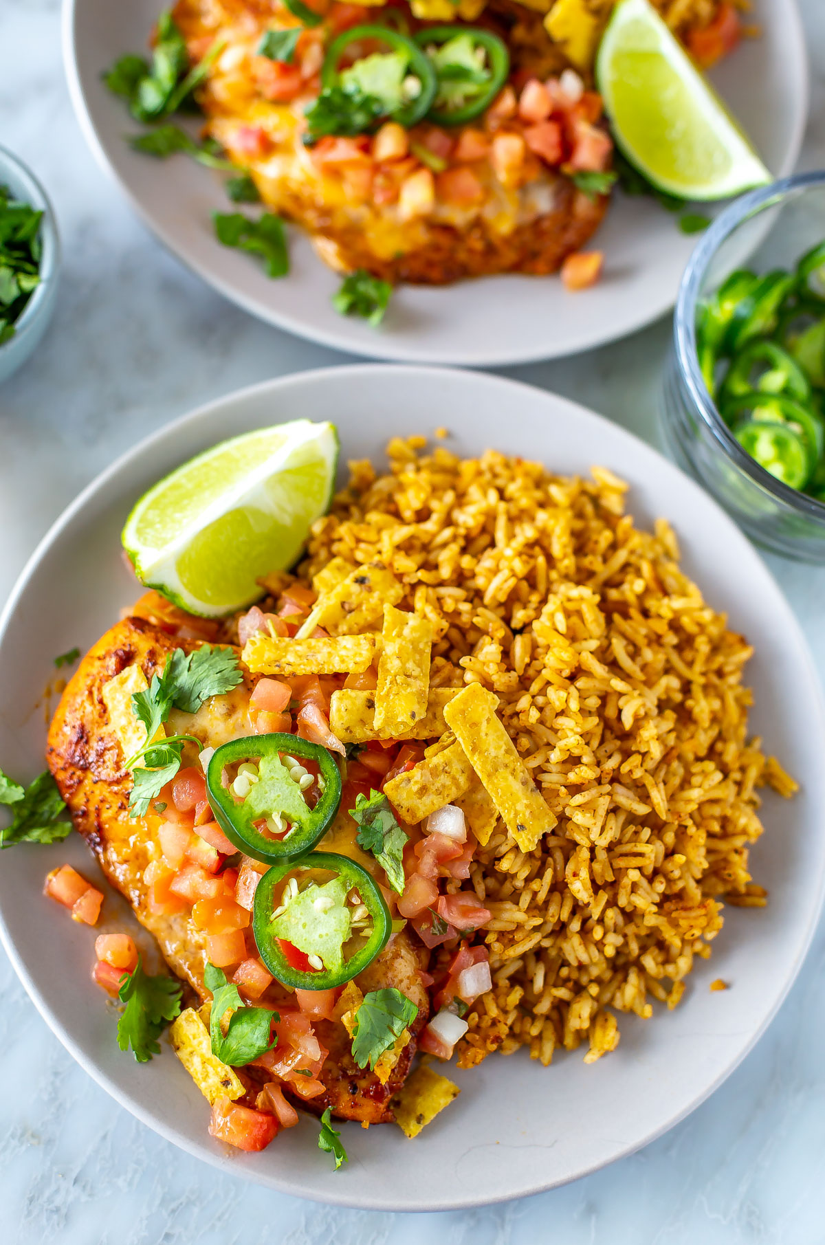 A plate of tequila lime chicken served alongside tex mex rice.