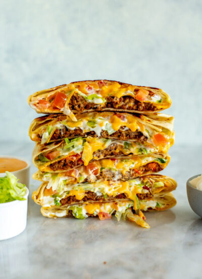 A copycat crunchwrap supreme that has been cut open stacked on top of another one.