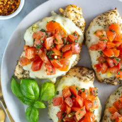 Three chicken breasts with bruschetta on a plate