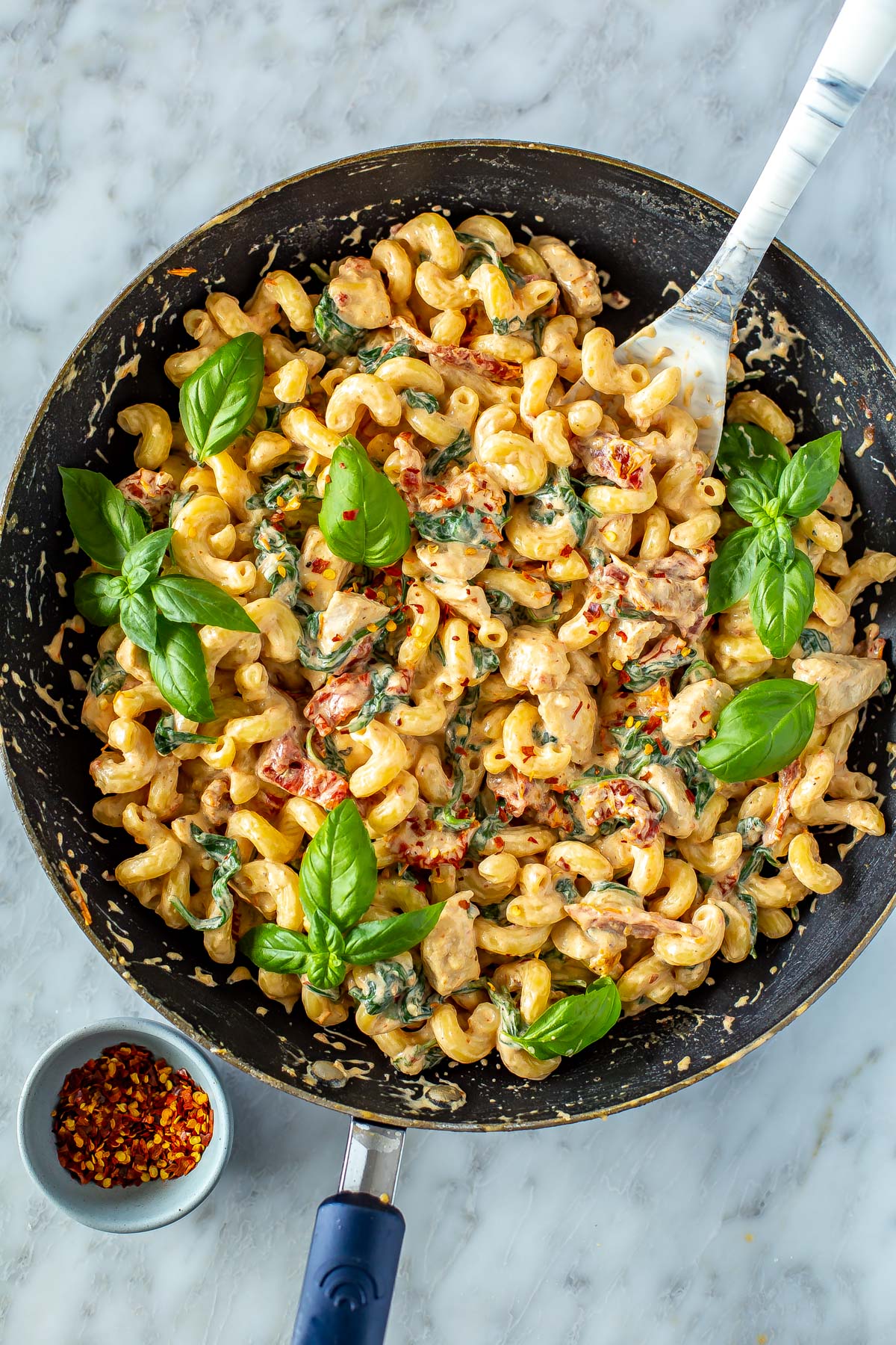 A skillet with creamy sundried tomato pasta.