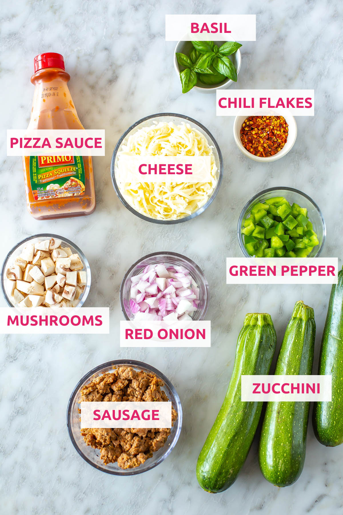 Ingredients for zucchini pizza boats: zucchini, pizza sauce, cheese, green peppers, mushrooms, red onion, sausage, basil and red chili flakes.