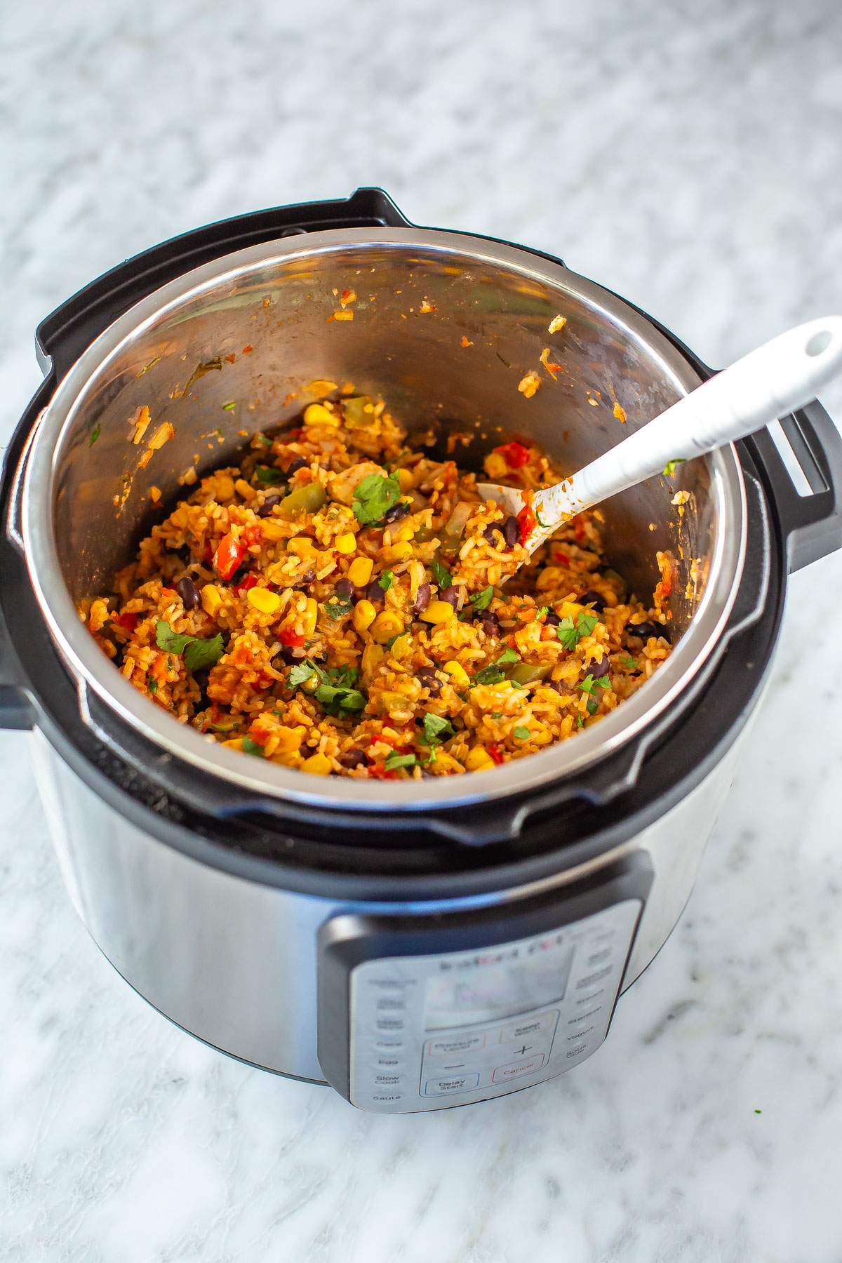 An Instant Pot with chicken burrito bowls filling inside.