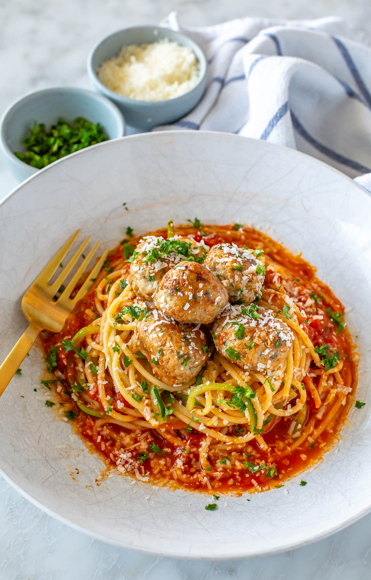 Baked turkey meatballs served on top of a bed os pasta and zucchini noodles.