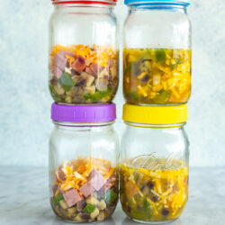 Four mason jars with microwave omelettes inside.