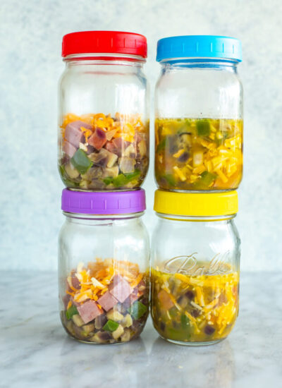 Four mason jars with microwave omelettes inside.