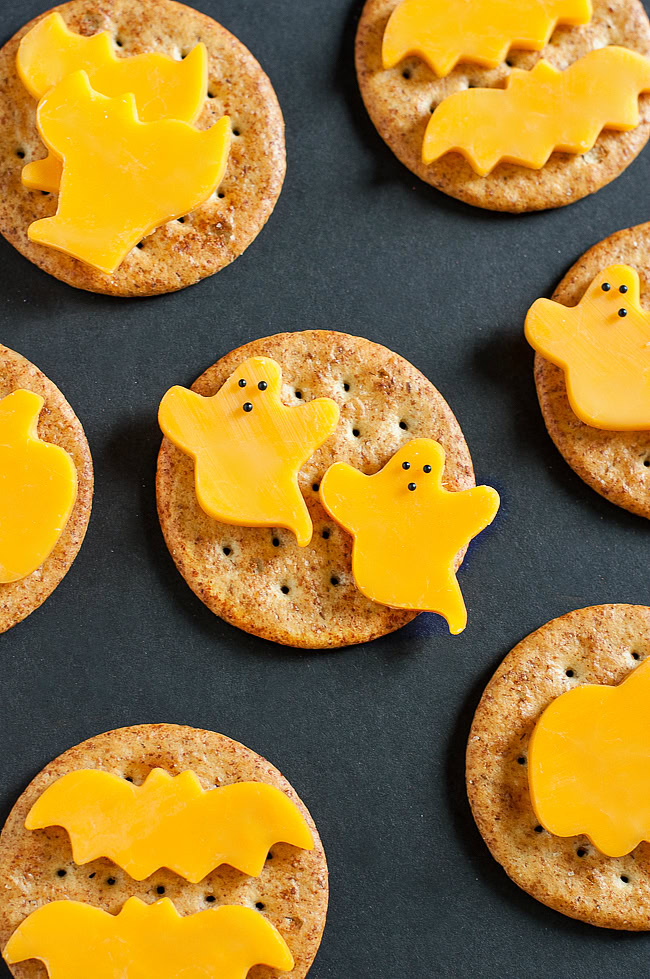 Cheese cut into the shape of ghosts on crackers