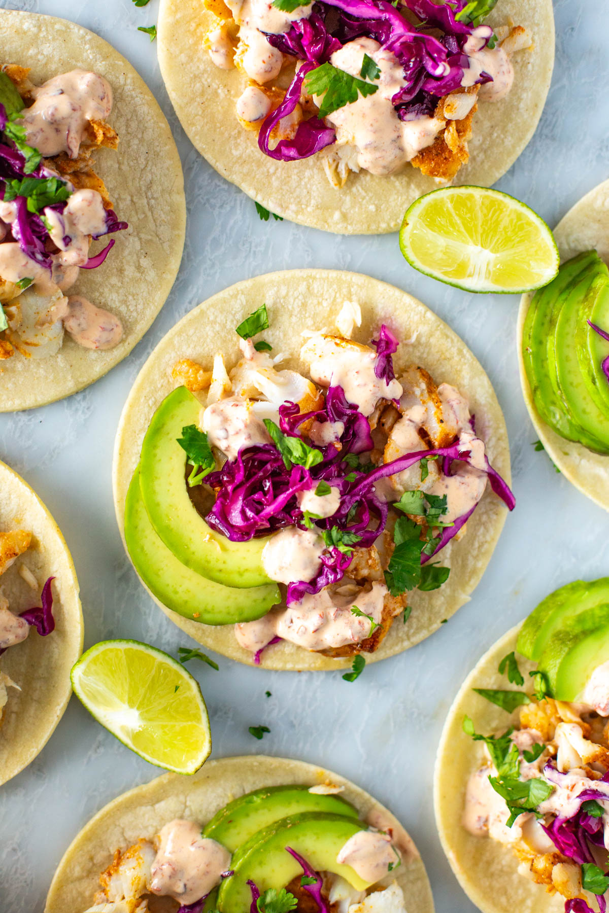 A close-up of homemade fish tacos with chipotle crema on top.