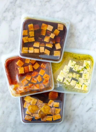 Four different types of marinated tofu each in its own reusable freezer bag.