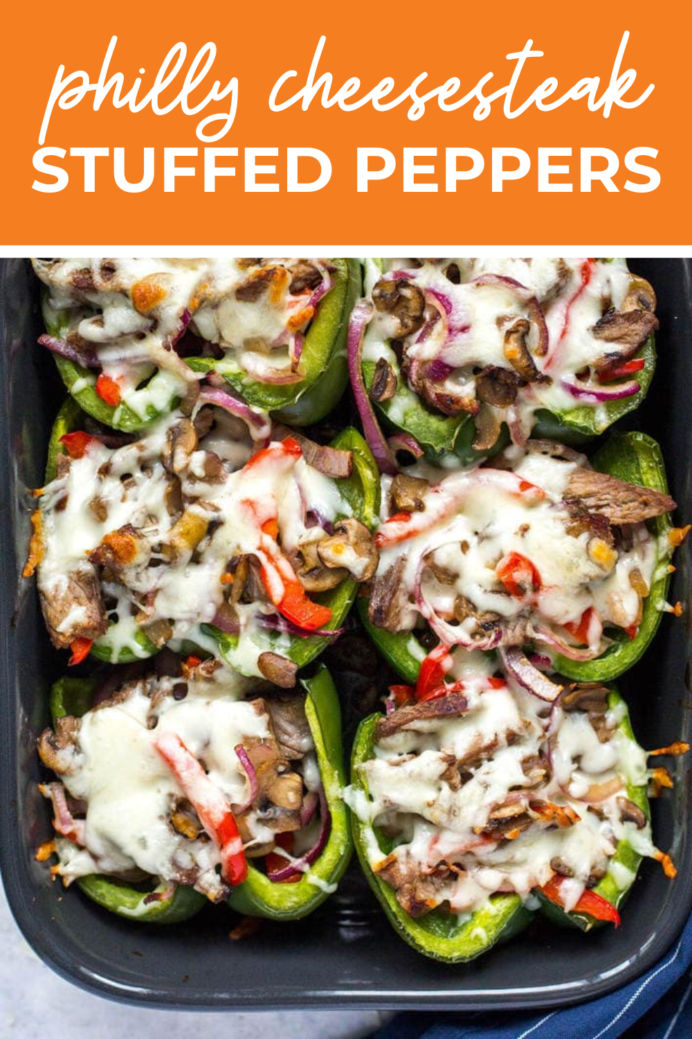 Philly cheesesteak stuffed peppers in a black casserole dish with the text "Philly Cheesesteak Stuffed Peppers" on top.