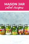 Lined up row of mason jar salads with pink banner at the top reading "mason jar salad recipes"
