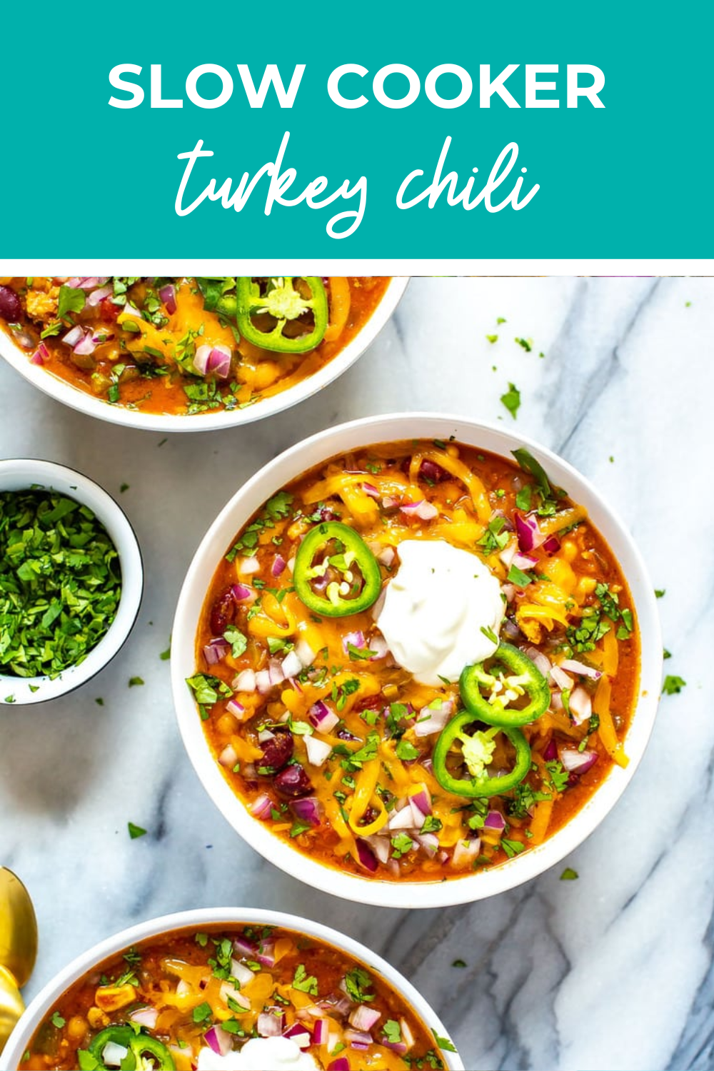 Two bowls prepared with turkey chili topped with jalapenos.