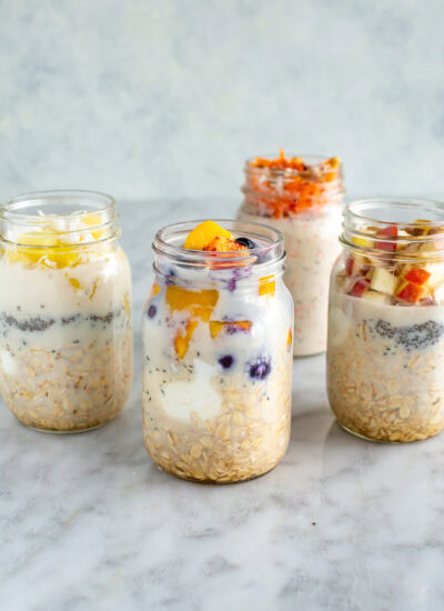 side front shot of four mason jars with overnight oats, each with different toppings