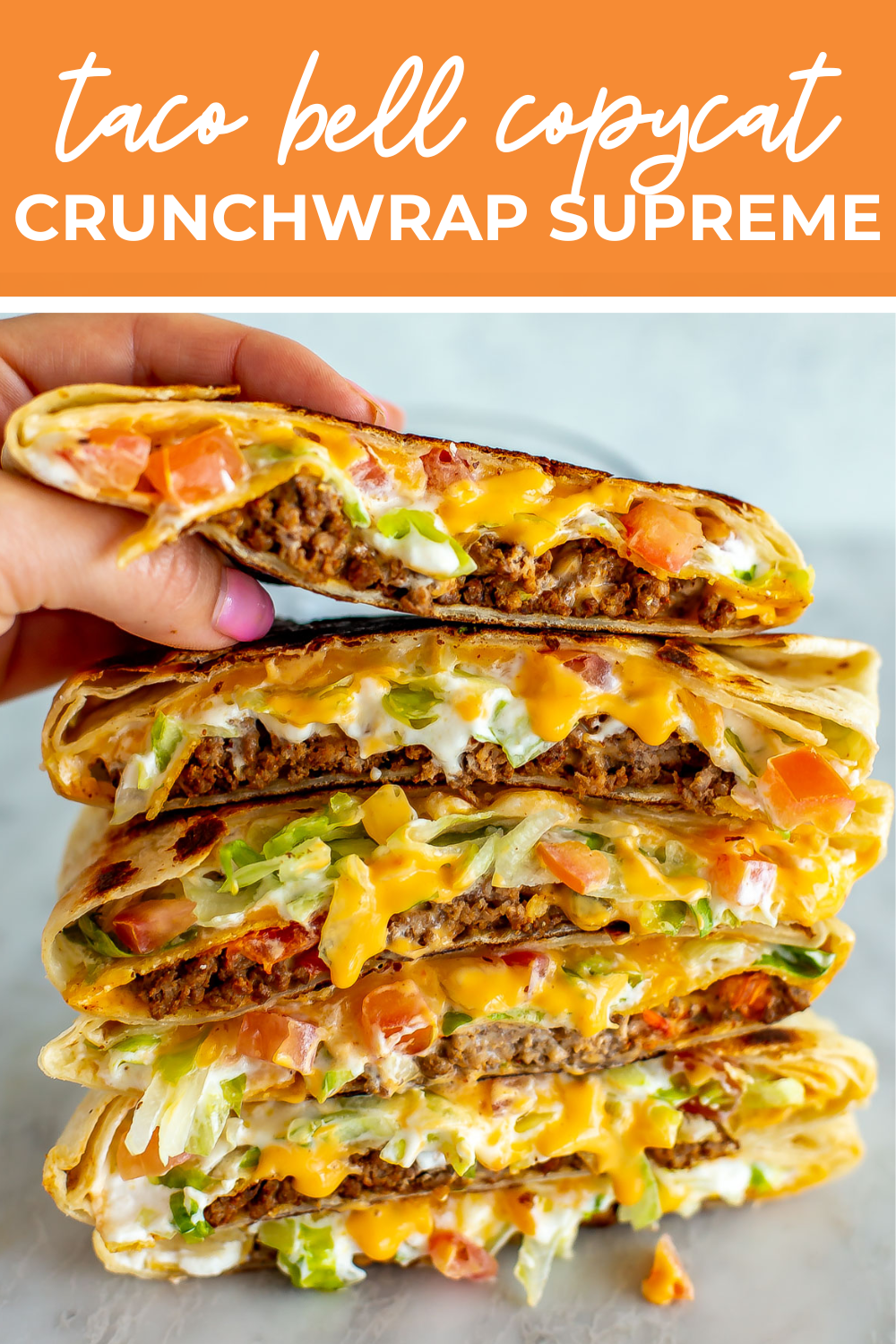 Overhead shot of plated dish with orange banner on the top- reading "taco bell copycat crunchwrap supreme"