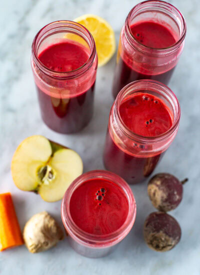 Overhead shot of four jars of beet juice without lids