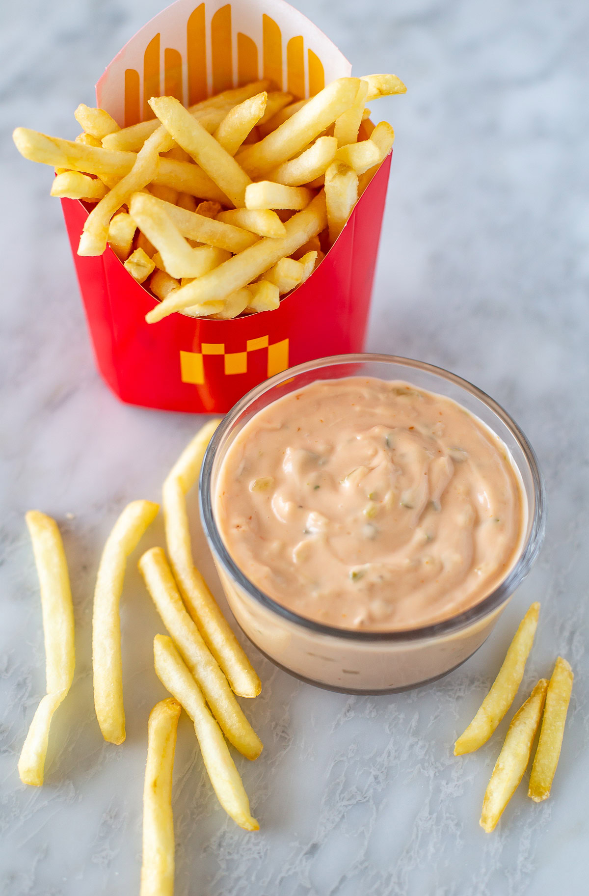 Overhead shot of big mac sauce h in a small bowl, next to french fries 1