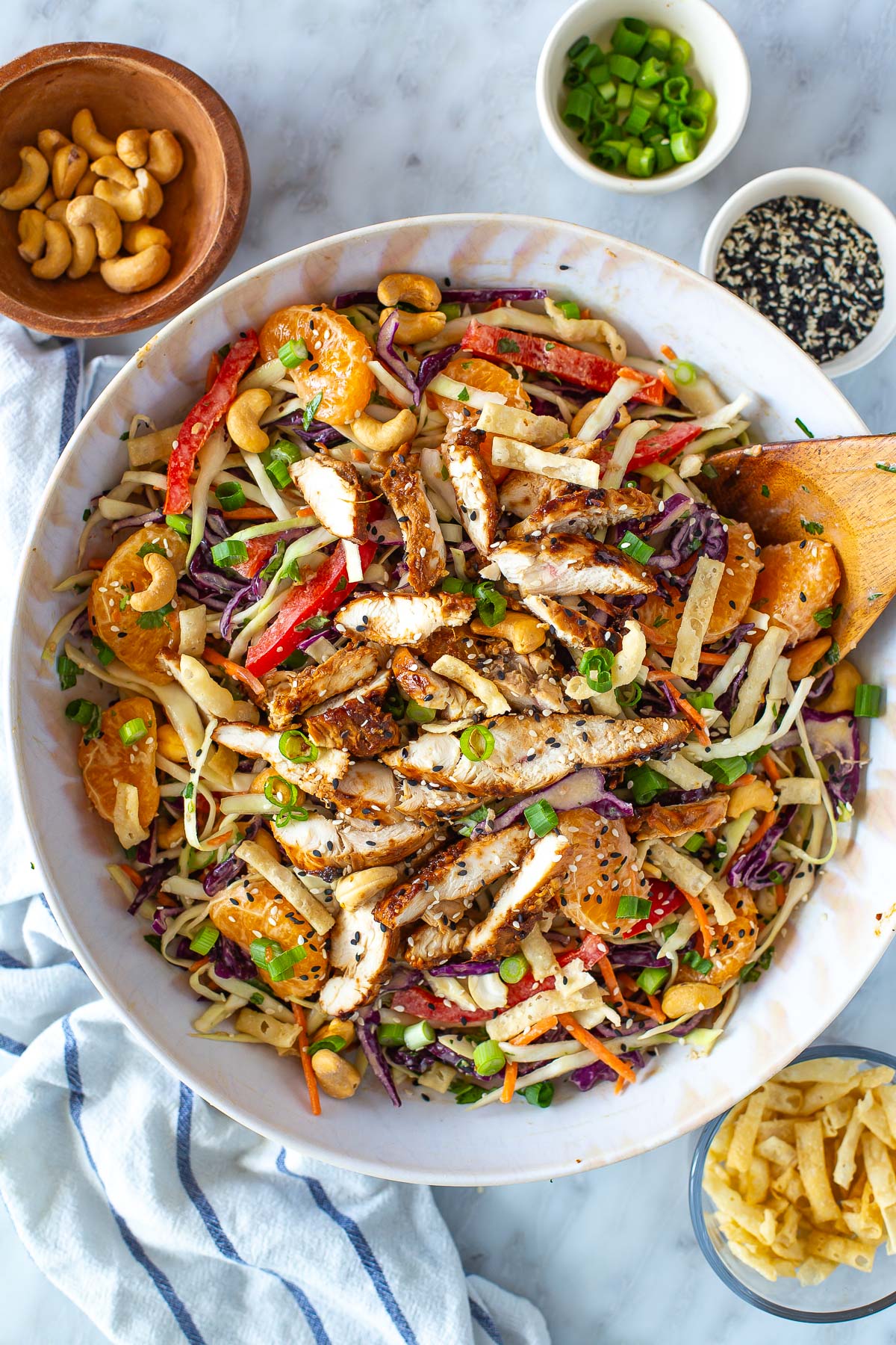 A big bowl of Mandarin Chicken salad with toppings on it.