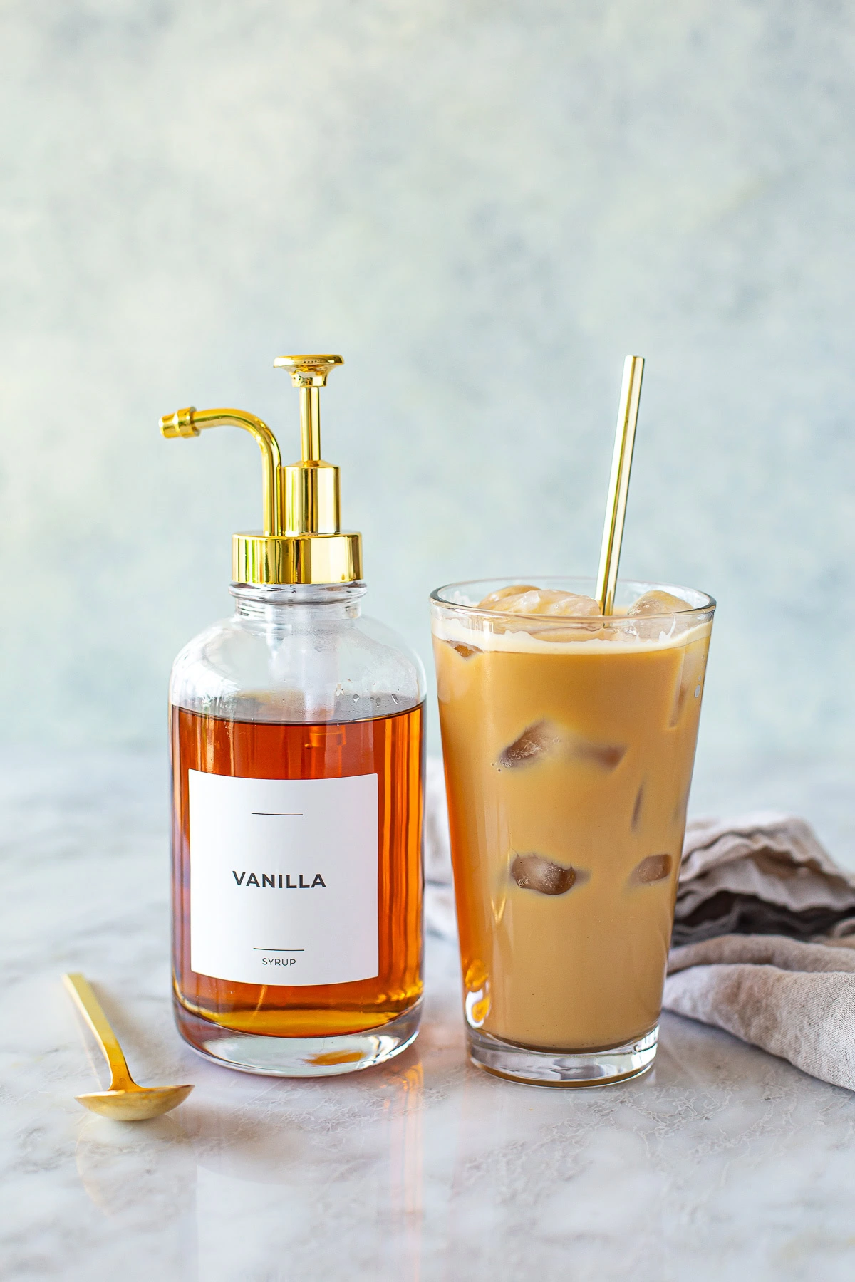 Side shot of homemade iced coffee and vanilla syrup pump